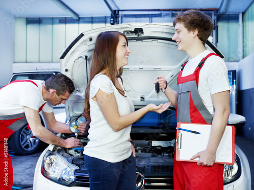Photo: Key delivery between customer and mechanic in front of a car Key delivery between customer and mechanic in front of a car