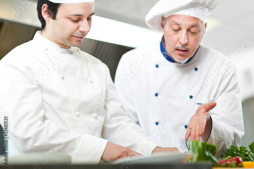 Photo: Two chefs cooking in a kitchen Two chefs cooking in a kitchen