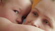 Mother and baby kissing, laughing and hugging.