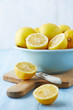 Fresh lemons in a bowl; whole and halved
