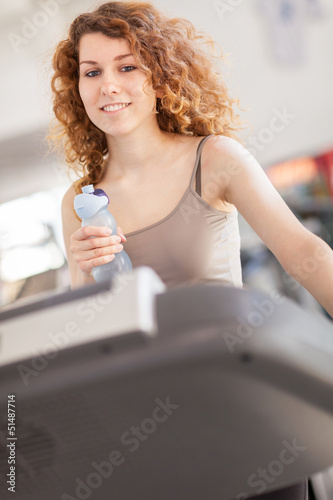 Photo: Woman is doing workout on a treadmill Woman is doing workout on a treadmill