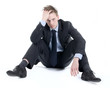 Depressed businessman sitting on the floor with hands in his hai