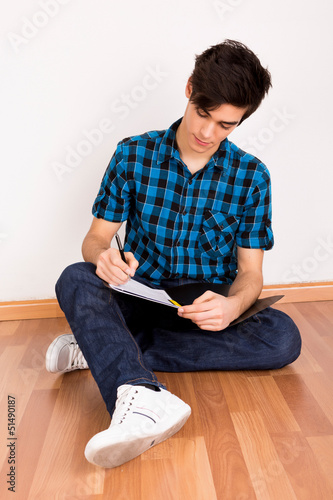 Photo: Young man studying at home Young man studying at home