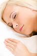Close up of sleepy woman in bed lying on the white cushion