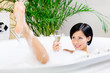 Woman taking a bath with suds drinks champagne
