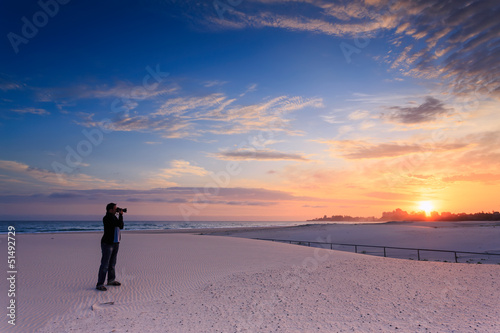 Photo: man takes a photograph of sunrise man takes a photograph of sunrise