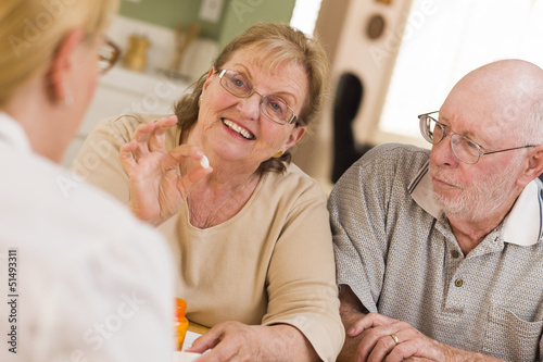 Photo: Doctor or Nurse Explaining Prescription Medicine to Senior Coupl Doctor or Nurse Explaining Prescription Medicine to Senior Coupl