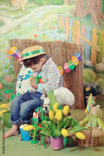 Photo: Easter theme with small boy with bunnies, chicks and eggs Easter theme with small boy with bunnies, chicks and eggs