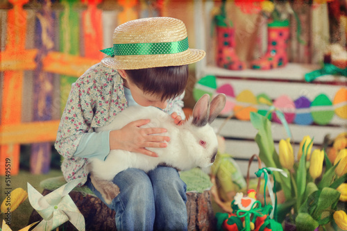 Photo: Easter theme with small boy with bunnies, chicks and eggs Easter theme with small boy with bunnies, chicks and eggs
