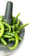 Green chilli and stone mortar over white back ground