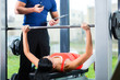woman and Personal Trainer in gym