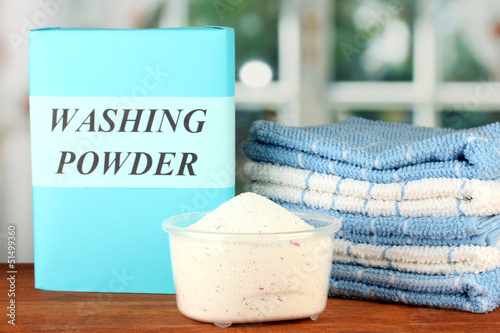 Photo: Box of washing powder with blue measuring cup and towels, Box of washing powder with blue measuring cup and towels,