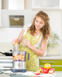 Portrait of a smiling pregnant woman cooking in her kitchen 