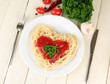 Cooked spaghetti carefully arranged in  heart shape and topped
