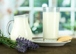 Glass of milk, a jug and cookies on a room background
