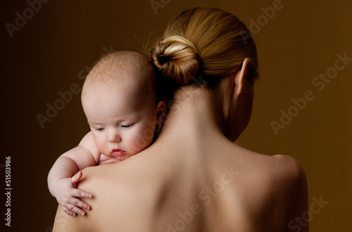 Photo: young mother holding a baby in her arms young mother holding a baby in her arms