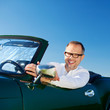glücklicher mann fährt cabrio