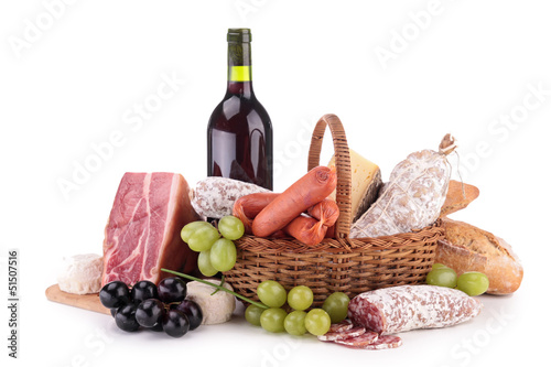 Photo: wicker basket with sausages, ham and wine wicker basket with sausages, ham and wine