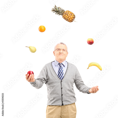 Photo: A mature man juggling fruits A mature man juggling fruits
