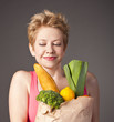 woman holding a bag full of healthy food