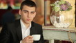 Businessman with a cup of coffee in hand. He looking at camera