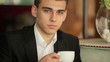 Close portrait of a businessman with a cup of coffee in the cafe