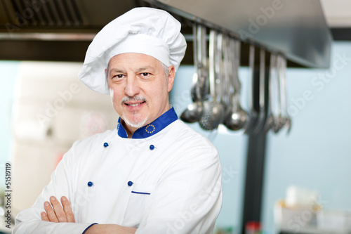 Photo: Male chef with arms crossed in restaurant kitchen Male chef with arms crossed in restaurant kitchen
