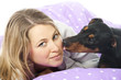 Young woman lying in bed with dog