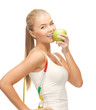 sporty woman with apple and measuring tape