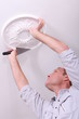 Foto: Decorator affixing a ceiling rose Decorator affixing a ceiling rose