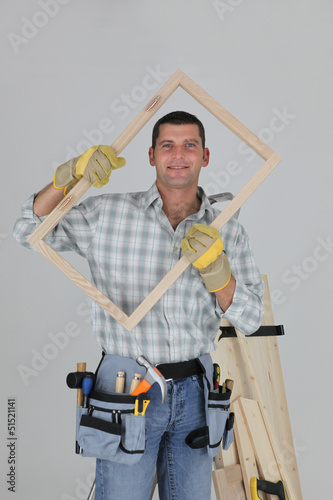 Photo: woodworker holding a window frame woodworker holding a window frame