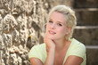 Blonde woman next to stone wall