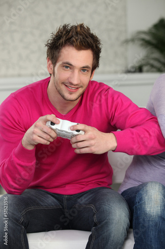 Photo: Young man with video game controllers Young man with video game controllers