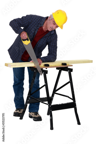 Photo: Tradesman sawing a plank Tradesman sawing a plank