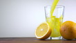 Orange juice pouring in glass on color background