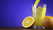 Orange juice pouring in glass on color background