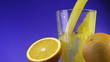 Orange juice pouring in glass on color background