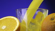 Video: Orange juice pouring in glass on color background Orange juice pouring in glass on color background