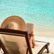 Young woman reading a book at beach