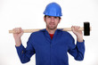 Photo: craftsman in blue overalls holding huge hammer craftsman in blue overalls holding huge hammer