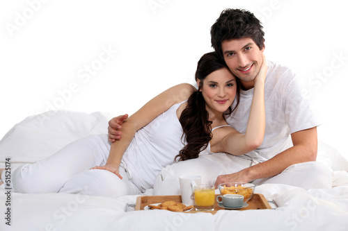 Photo: a couple having breakfast on bed a couple having breakfast on bed