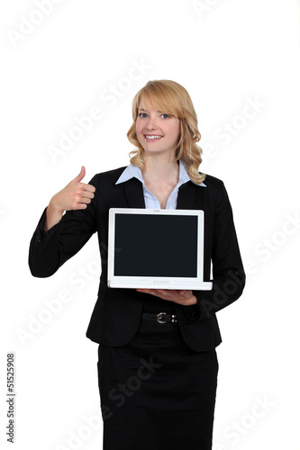 Photo: Businesswoman holding a laptop and giving the thumb's up Businesswoman holding a laptop and giving the thumb's up