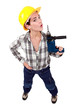 Photo: A female construction worker using a drill as a gun. A female construction worker using a drill as a gun.