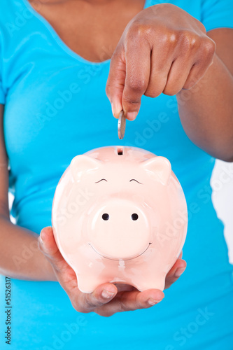 Photo: Black african american woman inseerting coin inside a smiling Pi Black african american woman inseerting coin inside a smiling Pi