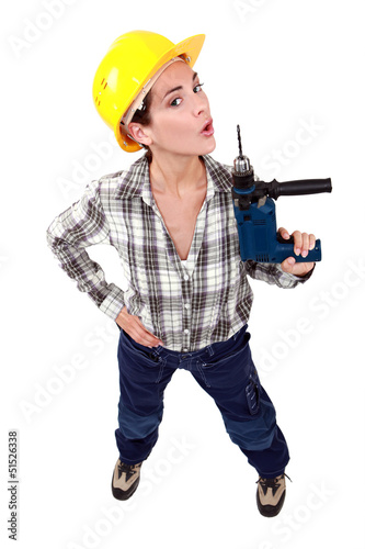 Photo: A female construction worker using a drill as a gun. A female construction worker using a drill as a gun.