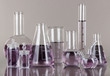 Test-tubes with light purple liquid on gray background