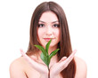 Beautiful young woman with green leafs isolated on white