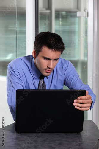 Photo: Businessman concentrating fully on laptop screen Businessman concentrating fully on laptop screen