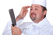 Chef looking at his reflection in a knife