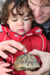 Father and son with a tortoise